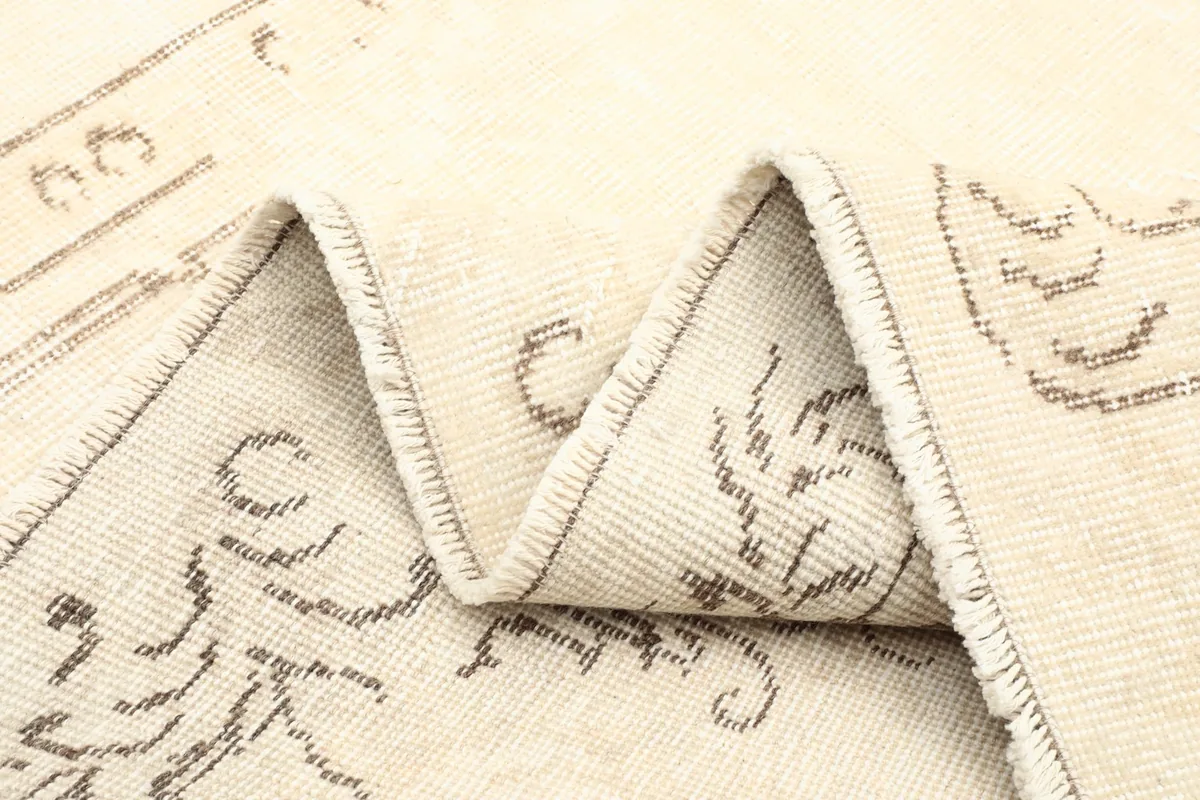 Multiple folds of the rug revealing the texture and faded patterns.