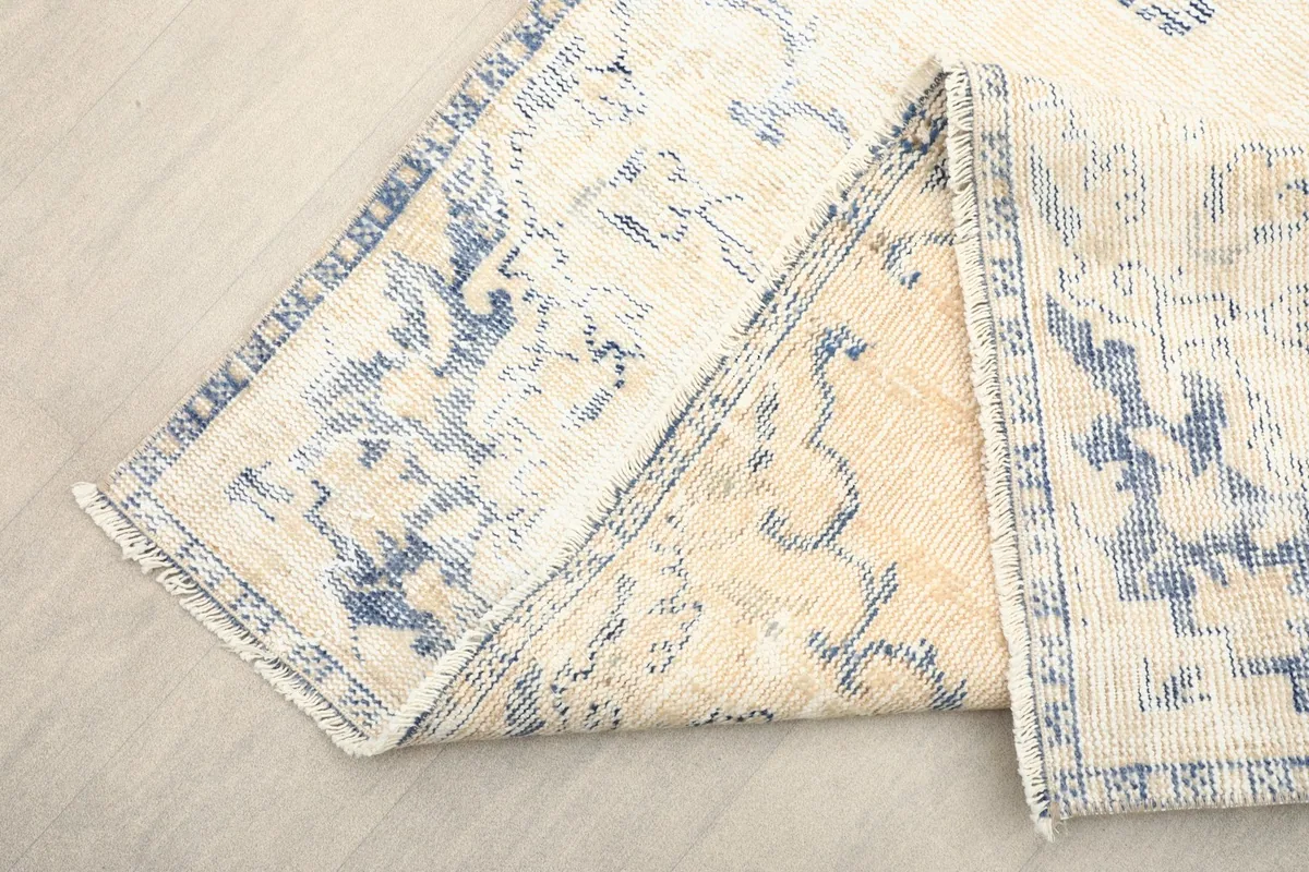 Folded section of the rug revealing the wool pile and cotton foundation