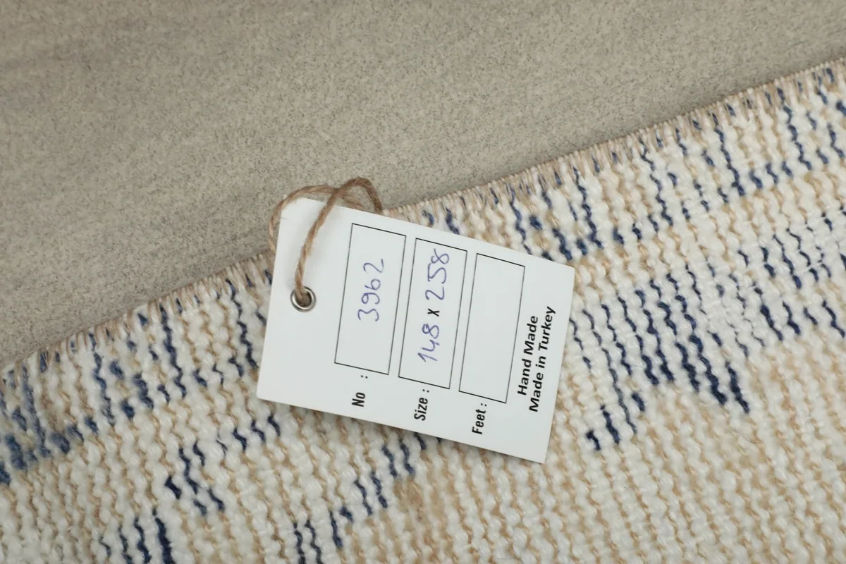 Product tag on the rug, indicating it is hand-made in Turkey with size details