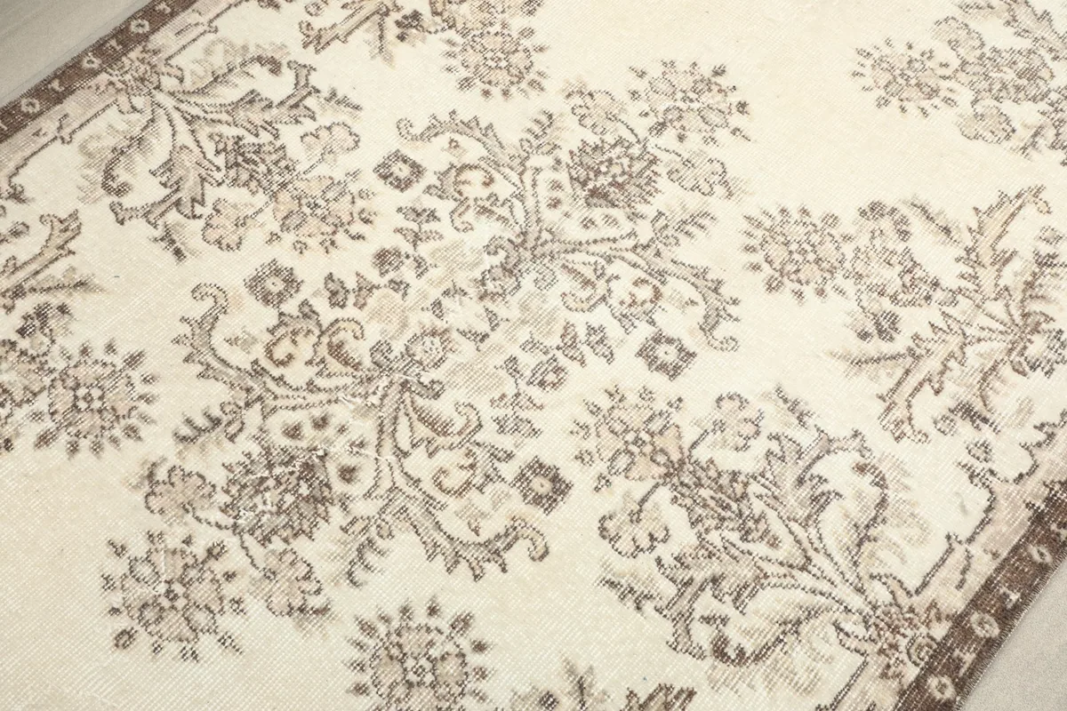 Detailed shot of the central floral and geometric motifs, showcasing the hand-knotted texture and color variation.