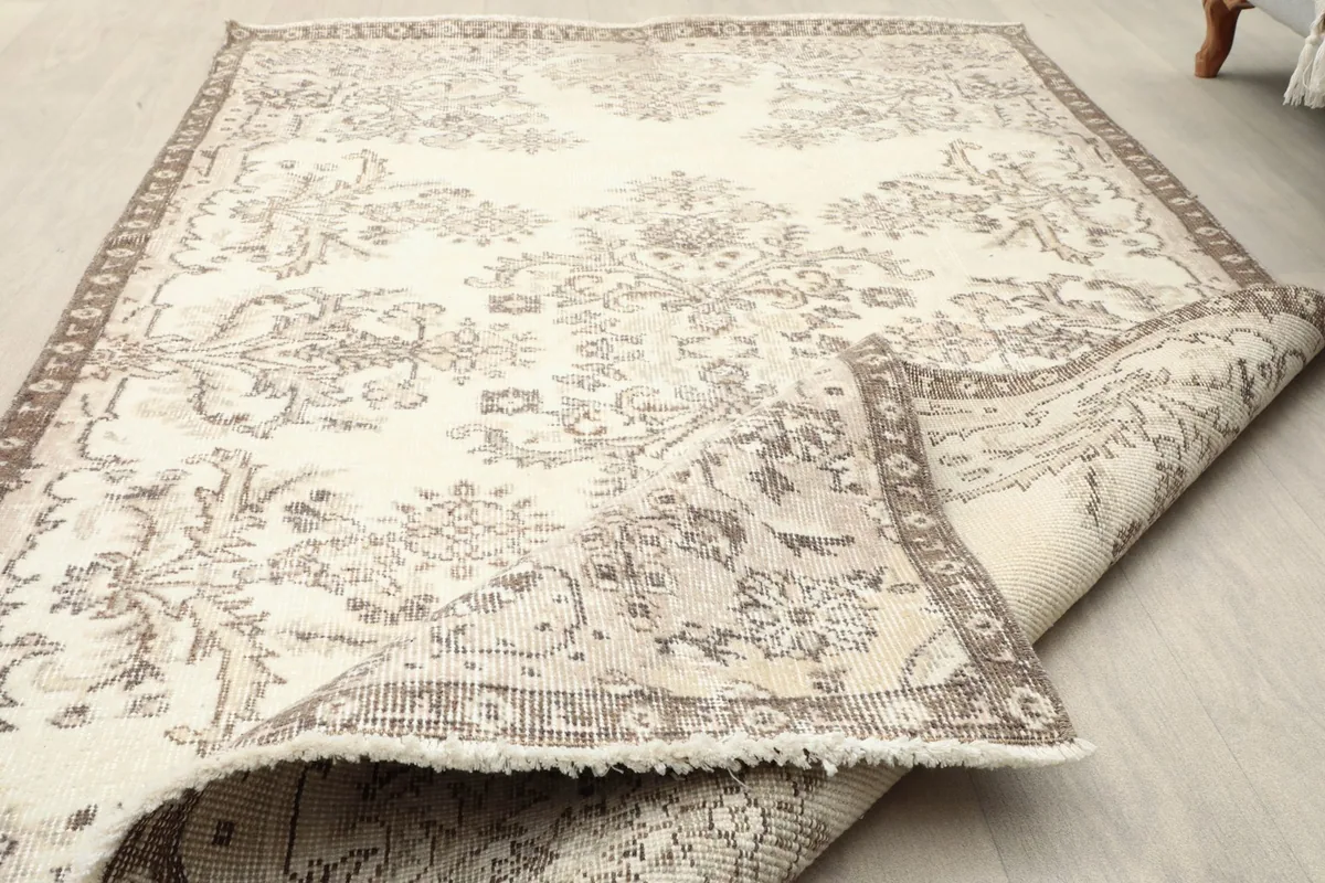 Top view of the rug with a corner folded back, showing the low pile and fringe details.