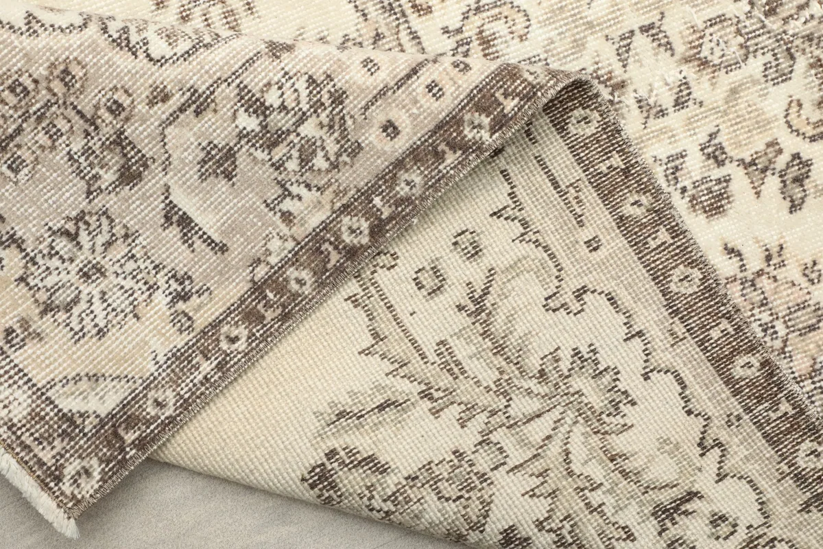 Close-up of the rug's fold, revealing the tight knotting and the condition of the edges and pile.