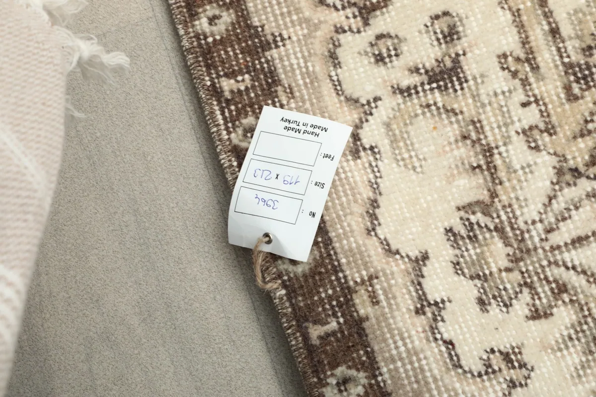 Close-up of the rug's tag, indicating its origin and dimensions, alongside the woven texture.