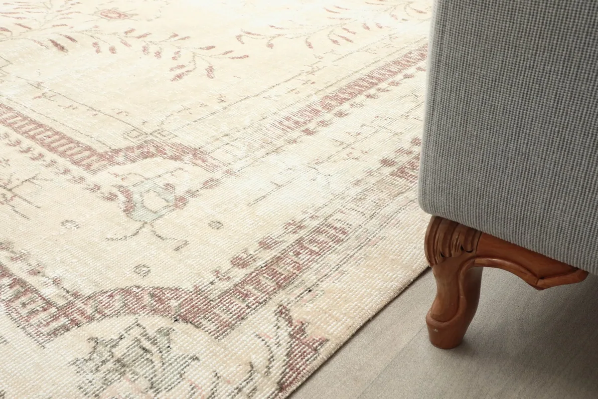 Detail of the rug extending under a furniture leg, showcasing its fit in a living space