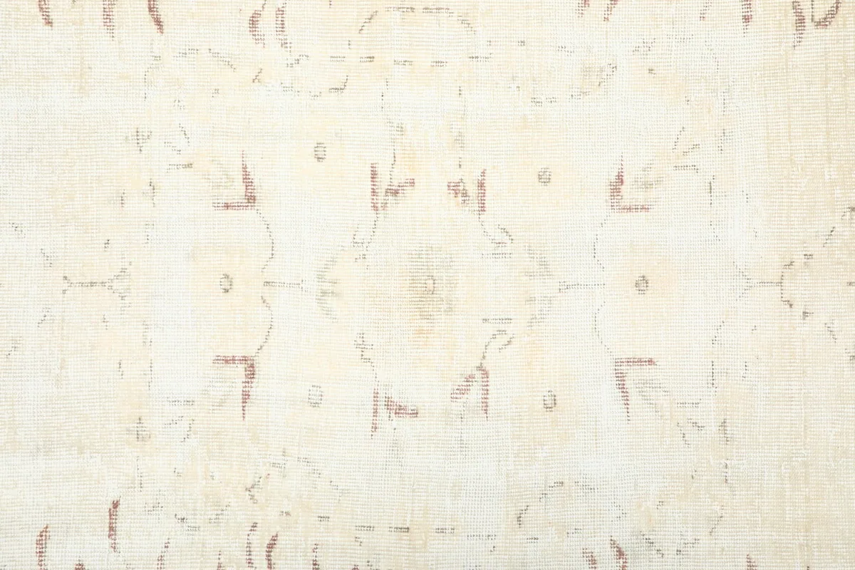 Close-up of the central field pattern, showing subtle rose botanical motifs on a cream background