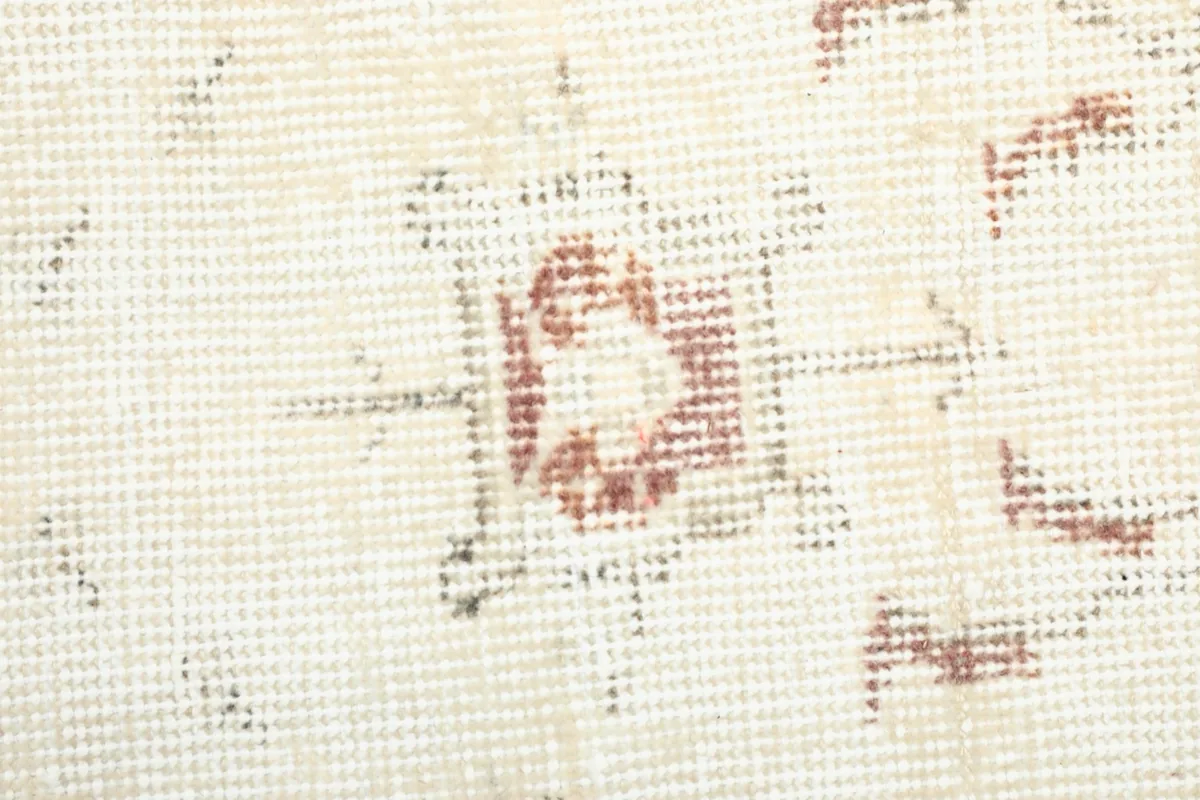 Macro view of the low wool pile and the intricate knotting, revealing areas of gentle wear