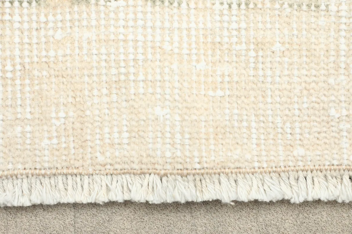 Close-up detail of the hand-knotted fringe and cotton foundation of the rug