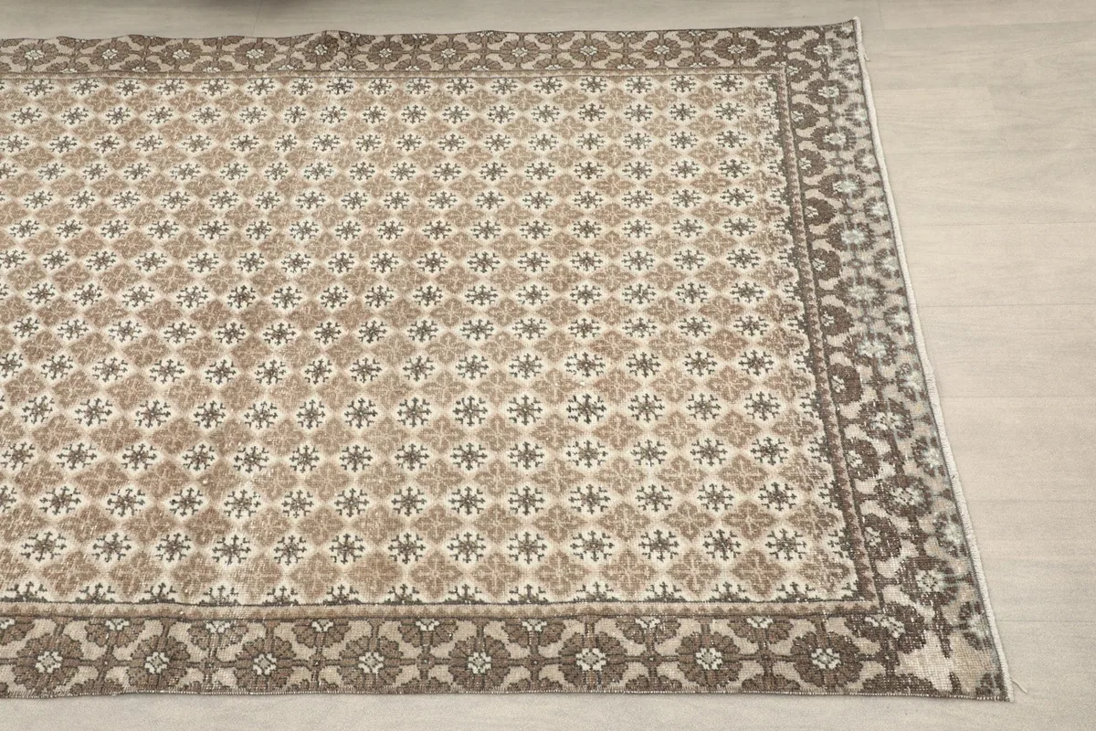 Close-up angle view of the rug's tan field and brown border pattern