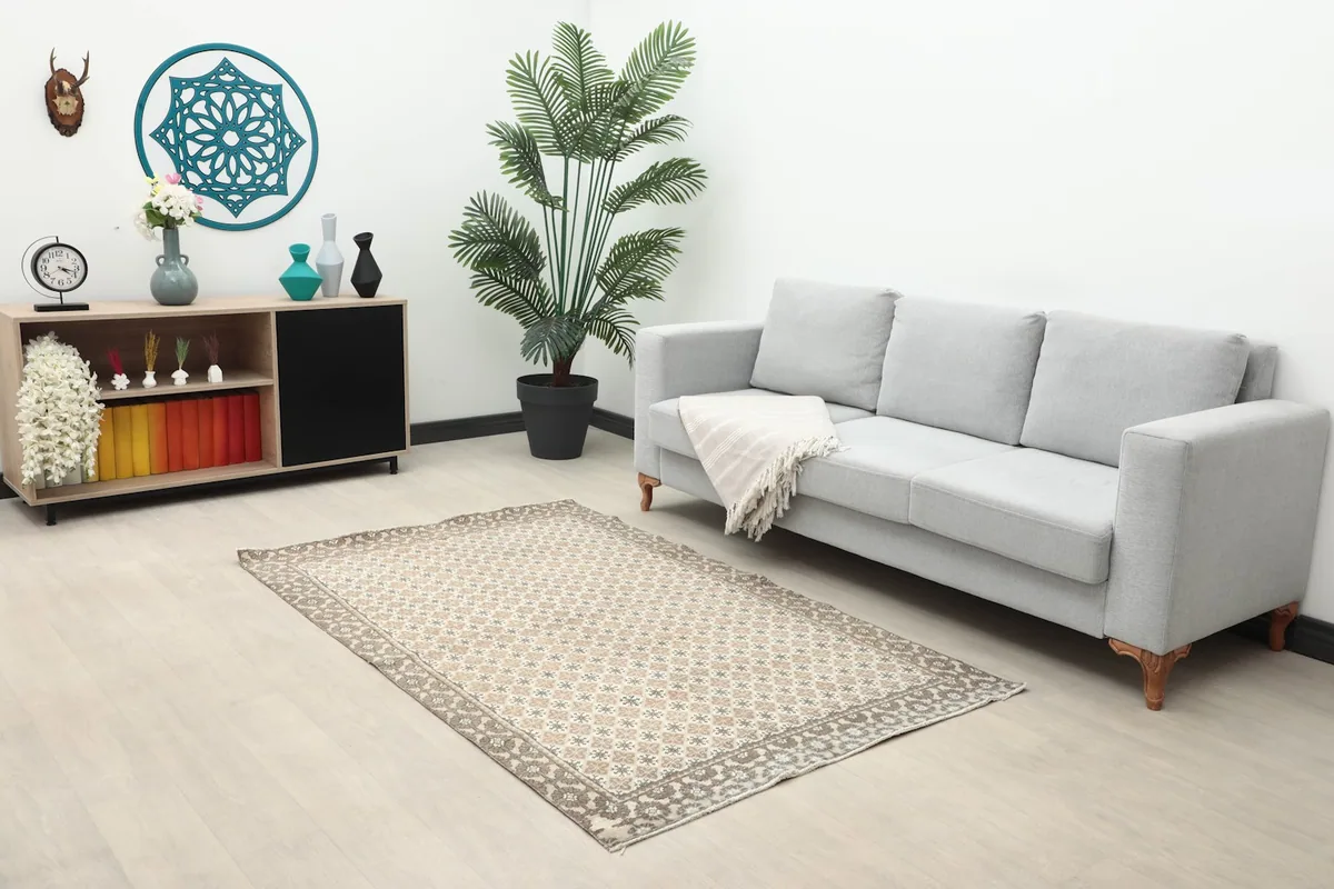Vintage Anatolian rug placed in a living room setting with a gray sofa