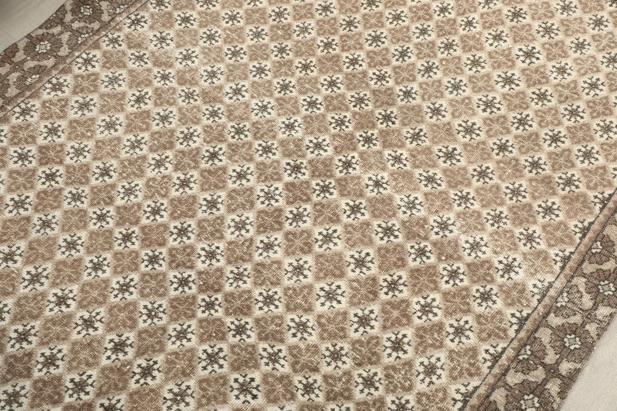 Detailed view of the repeating geometric patterns across the rug's field