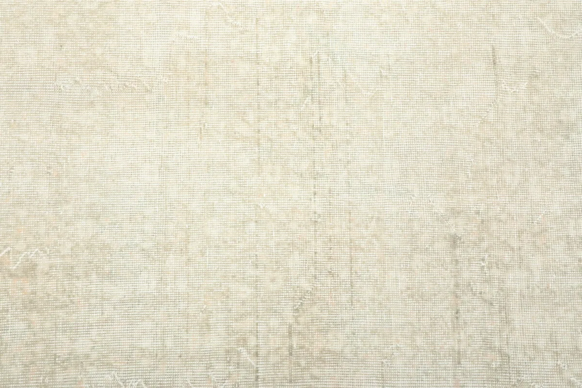 Overhead view of a section of the ivory rug, revealing its faded design