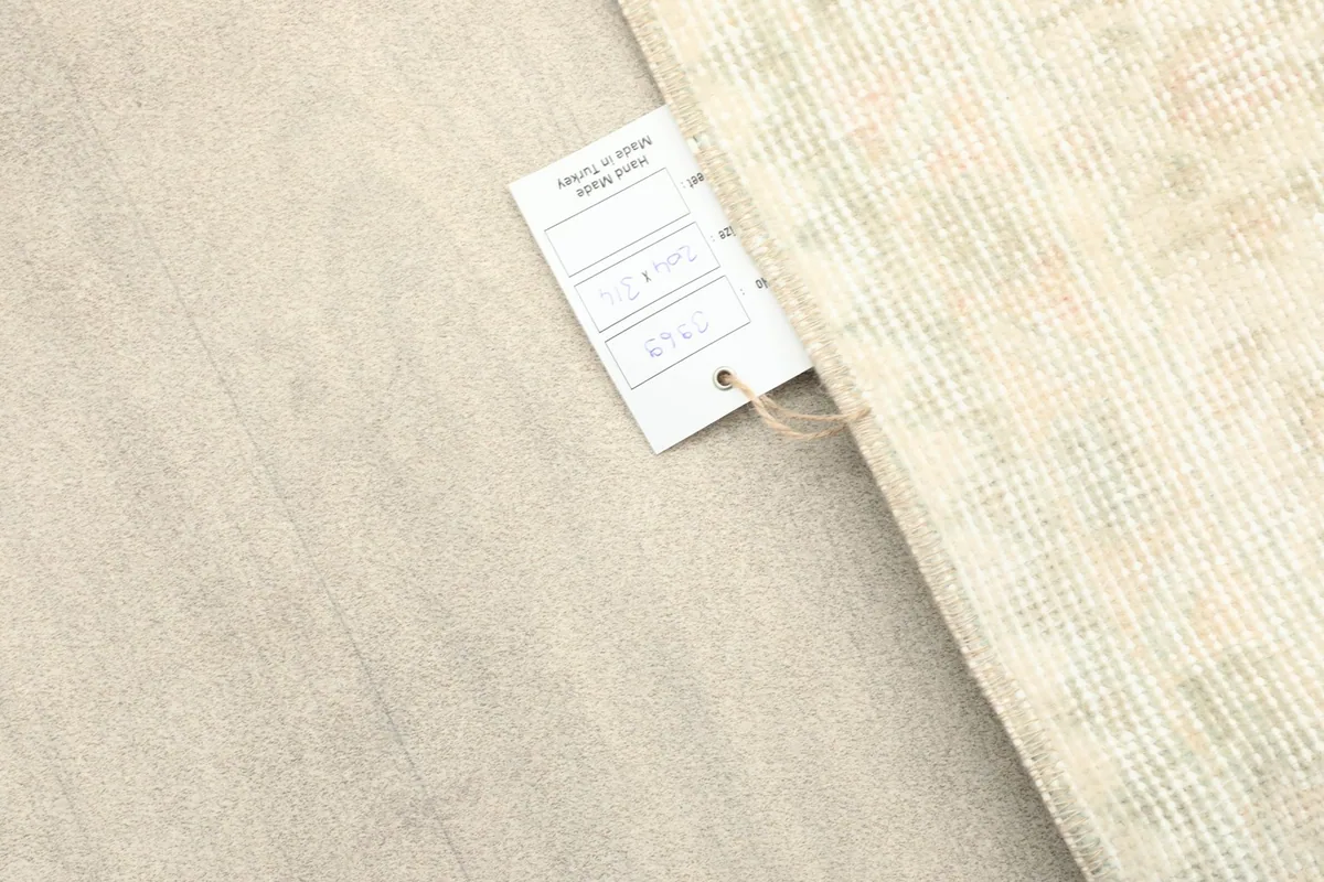 Rug tag partially visible next to the rug's edge on a light colored floor
