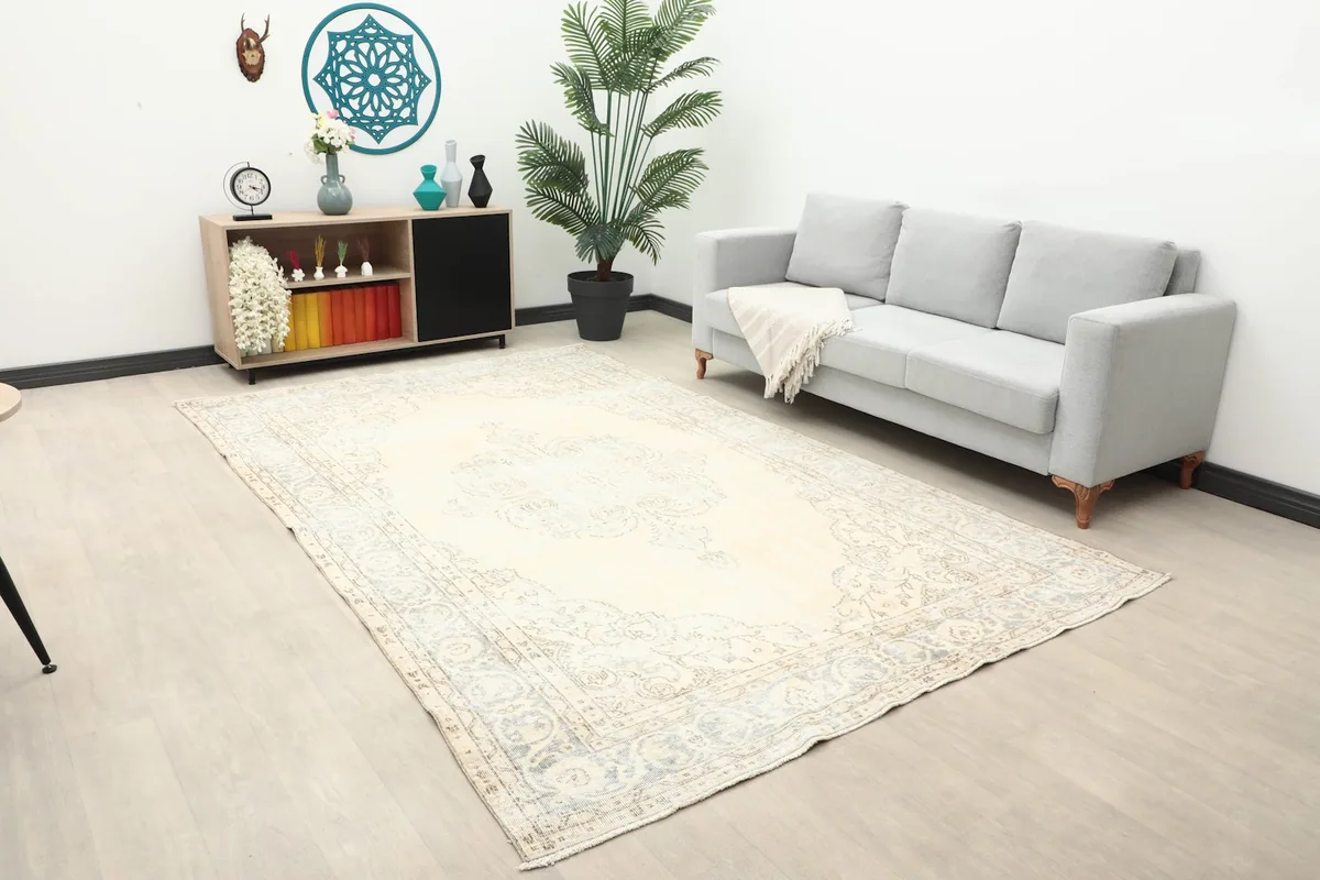 Large area rug showing its scale in a room with a light gray couch and wooden console.