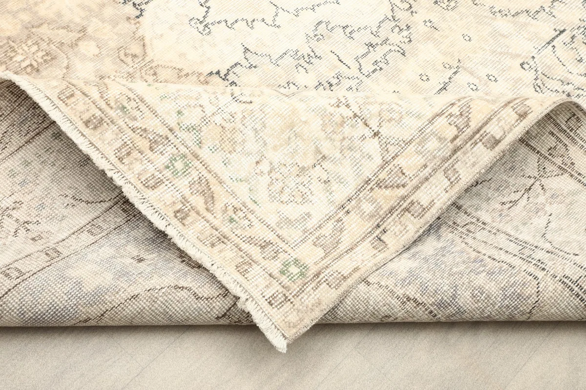 Corner of the rug folded to show the hand-knotted wool pile on cotton foundation