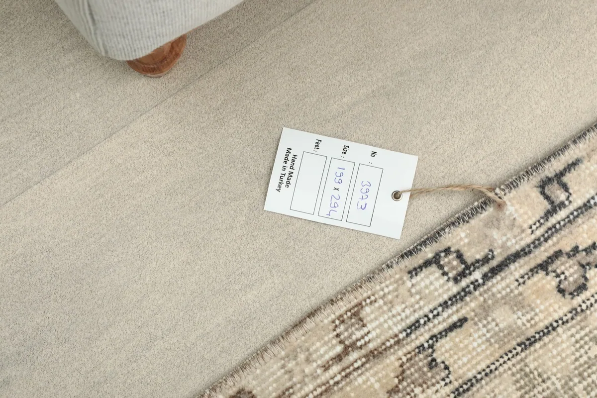 Tag displaying the rug's dimensions and origin, placed on the rug's surface