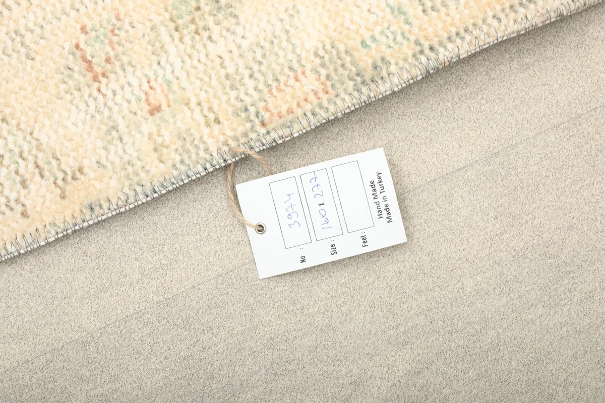 Detail of the rug tag, confirming its hand-knotted origin and material