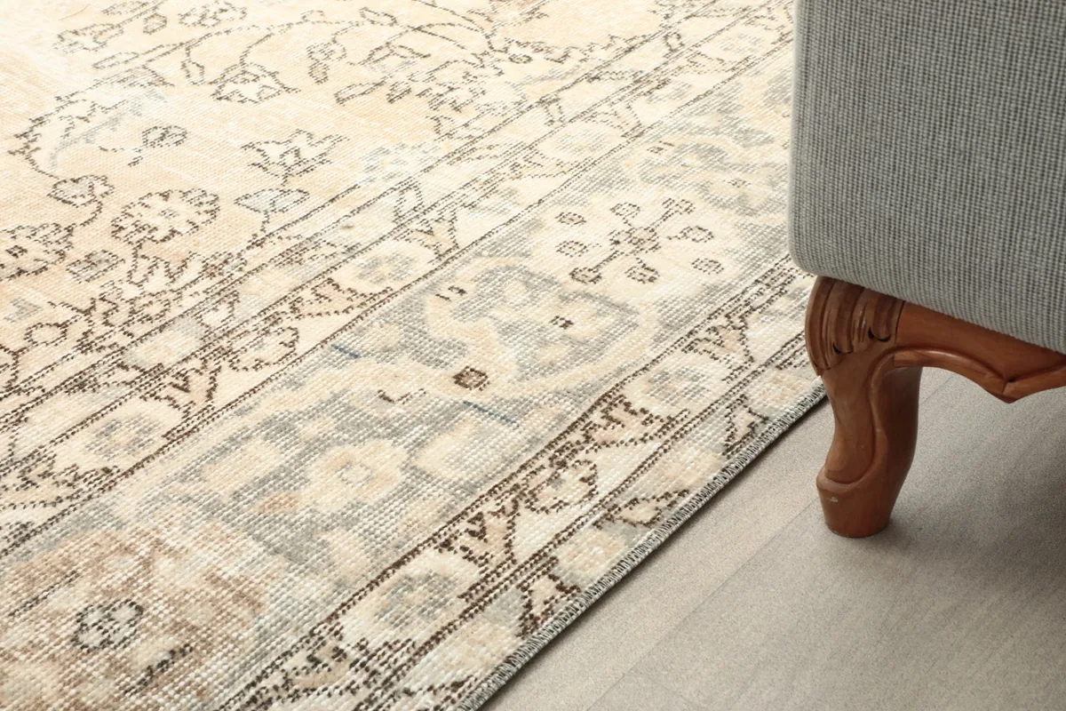 Rug's edge next to a furniture leg, demonstrating its placement in a home environment