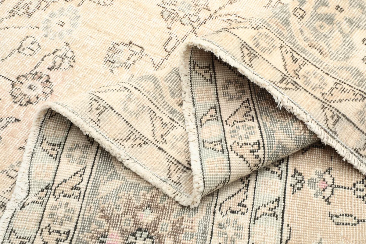 Folded edge of the rug, showing the wool pile and cotton foundation from the side