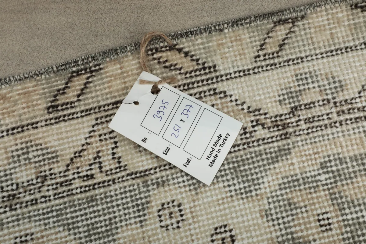 Close-up of the product tag showing rug dimensions 251 x 377 cm and 'hand made in Turkey'