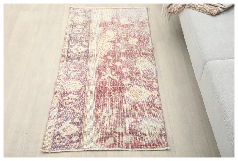 Full top view of the vintage rose and purple patchwork floral rug on a light floor.