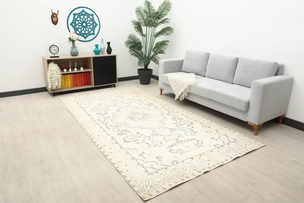 Vintage cream and charcoal rug anchoring a modern living room setup with a sofa and console.