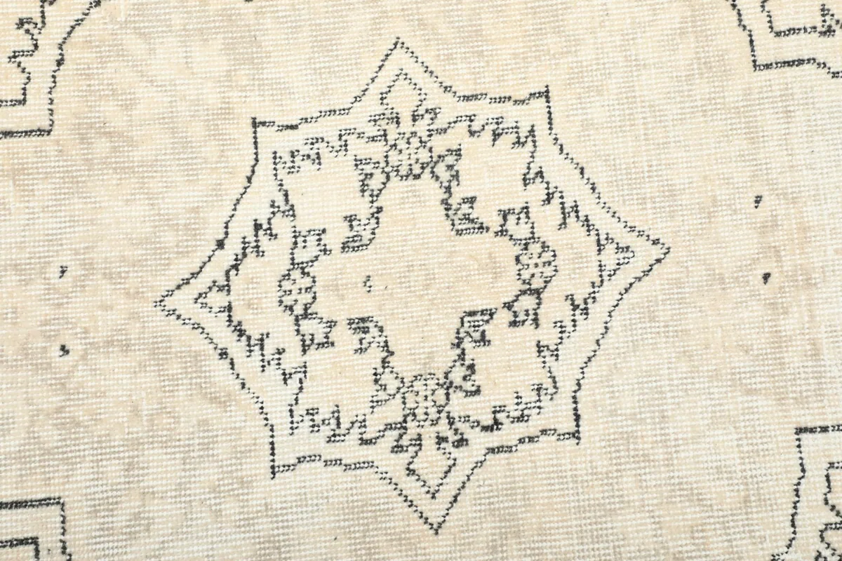 Detailed view of the intricate star-like pattern within the rug's central medallion.