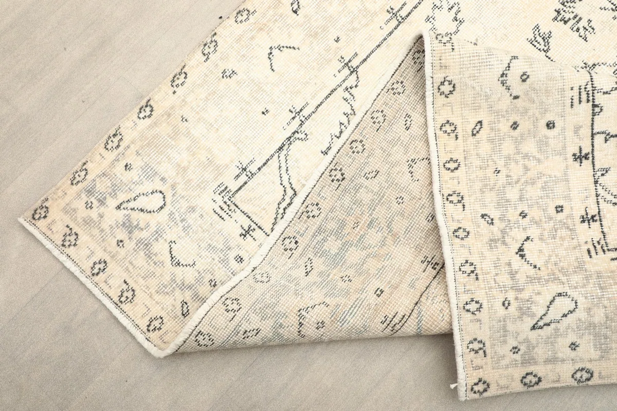 Folded section of the rug, showing the reverse side and the hand-knotted construction.
