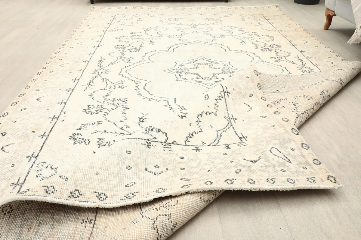 Rug partially folded, displaying the full design and the flexibility of the vintage wool material.