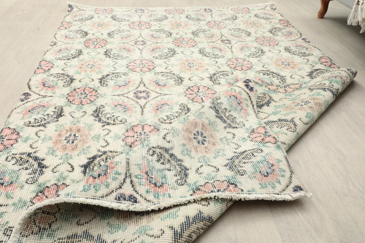 Close-up of the low pile texture and the overall condition of the vintage wool rug