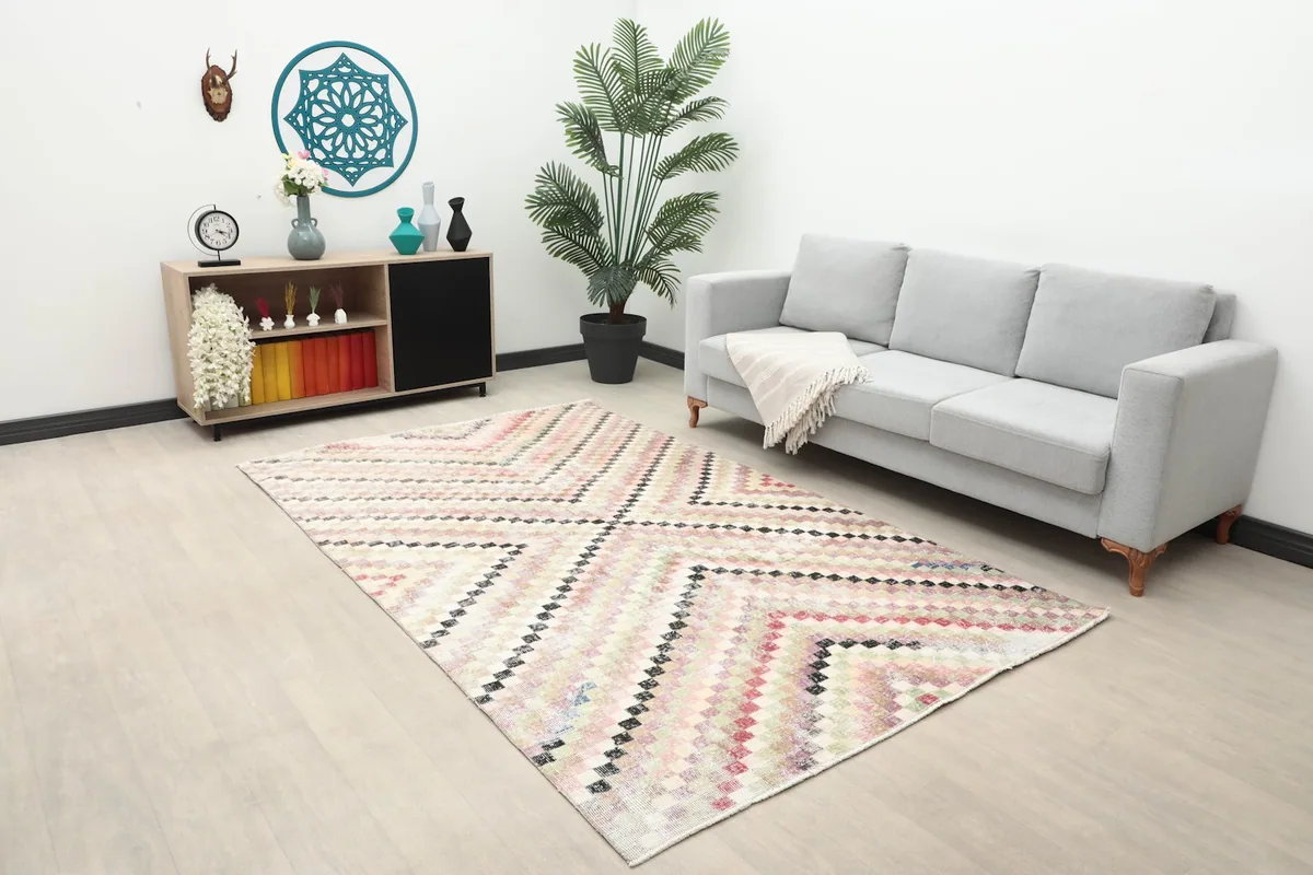 Beige multicolor vintage rug placed in a living room setting with a gray sofa