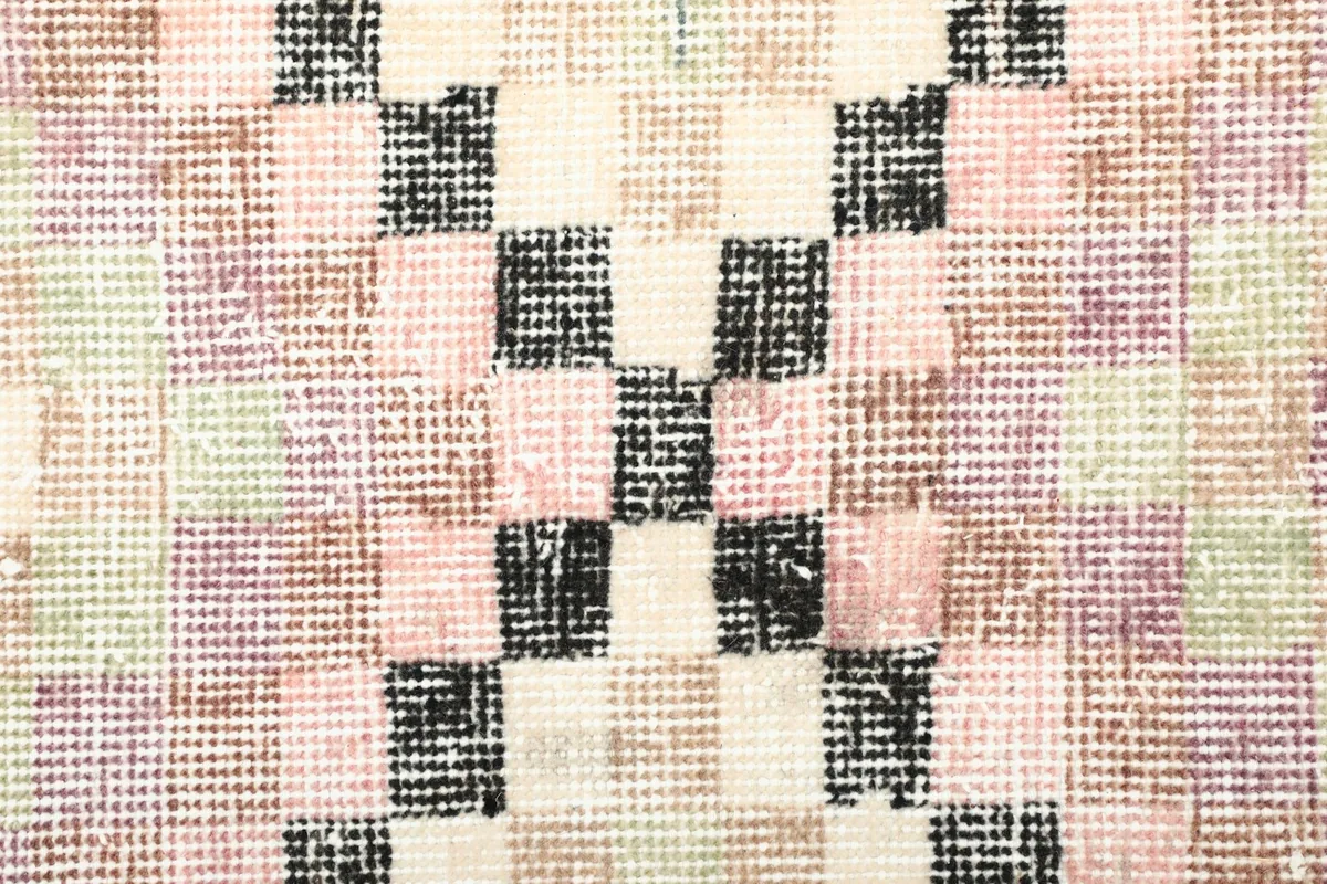 Close-up of the low wool pile and the hand-knotted texture of the vintage rug