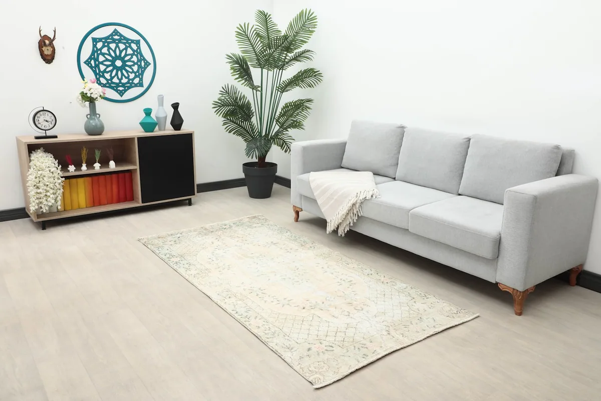 The small area rug placed in a living room setting with a sofa and console table.