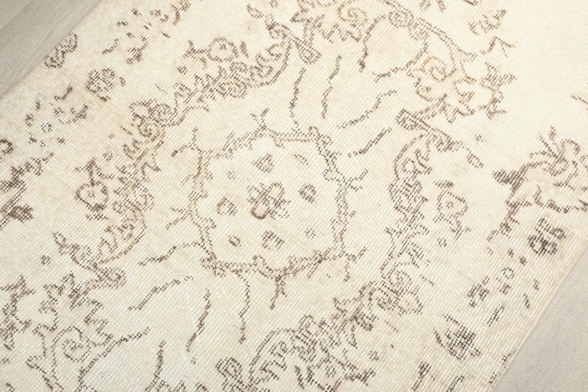 Detailed view of the central medallion-like pattern and surrounding faded floral elements.