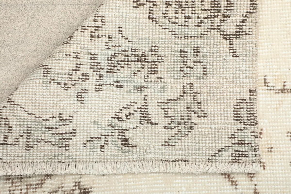 Corner view showing the back of the hand-knotted wool rug with its cotton foundation and fringes.
