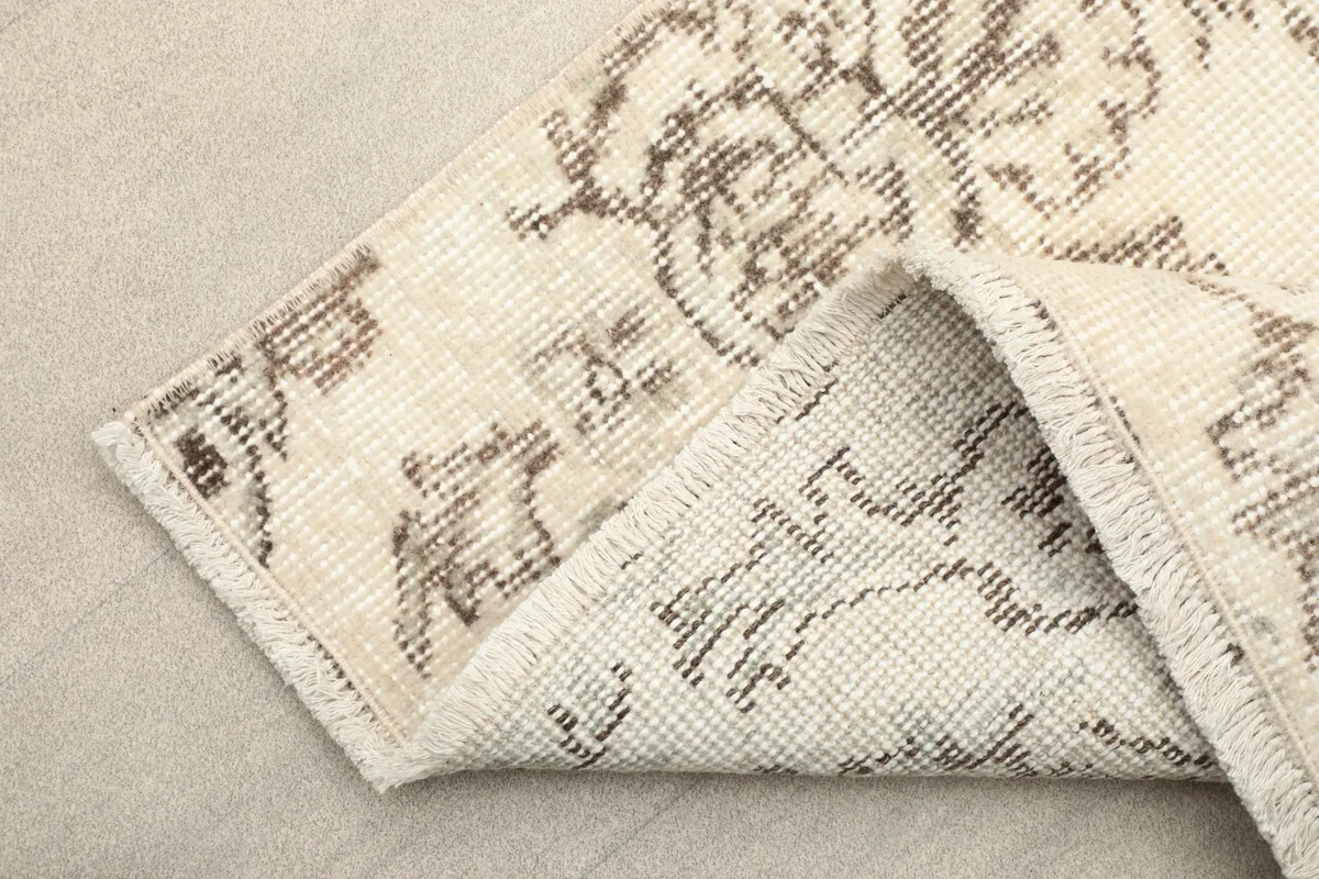 Folded corner of the runner, displaying the wool pile, cotton foundation, and hand-knotted structure.