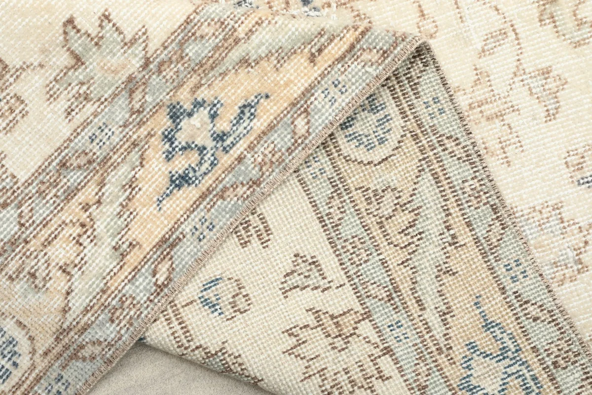 Another view of the rug folded, showing the intricate details of the border and foundation.