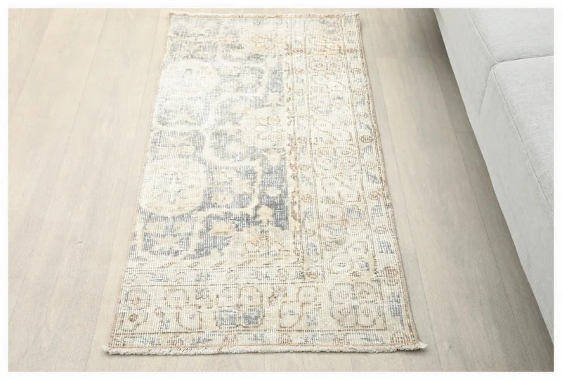 Full top view of the beige and gray vintage Anatolian rug on a light floor.