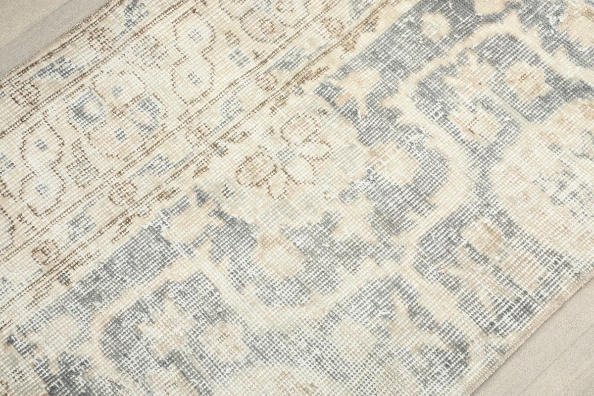 Close-up of the subtle color variations and intricate, softened patterns on the rug.