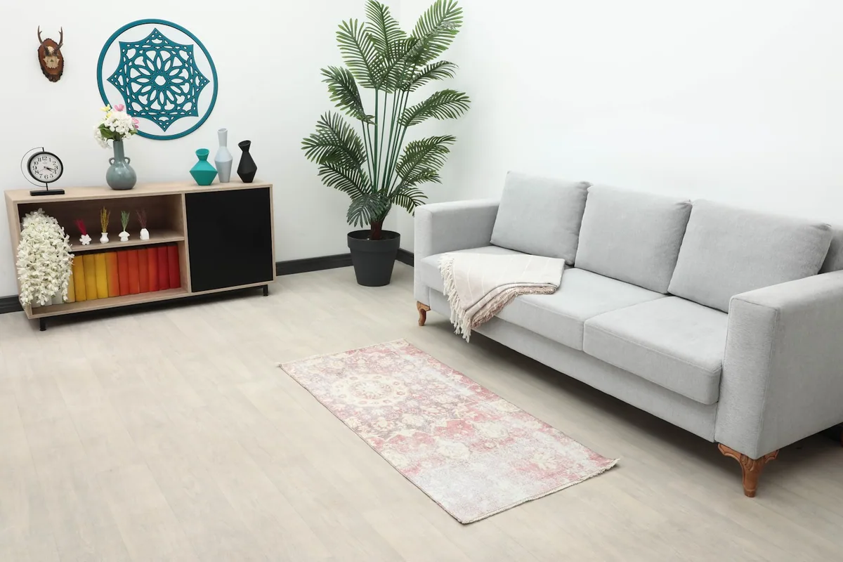 Vintage rose and ivory rug placed in a living room setting next to a sofa