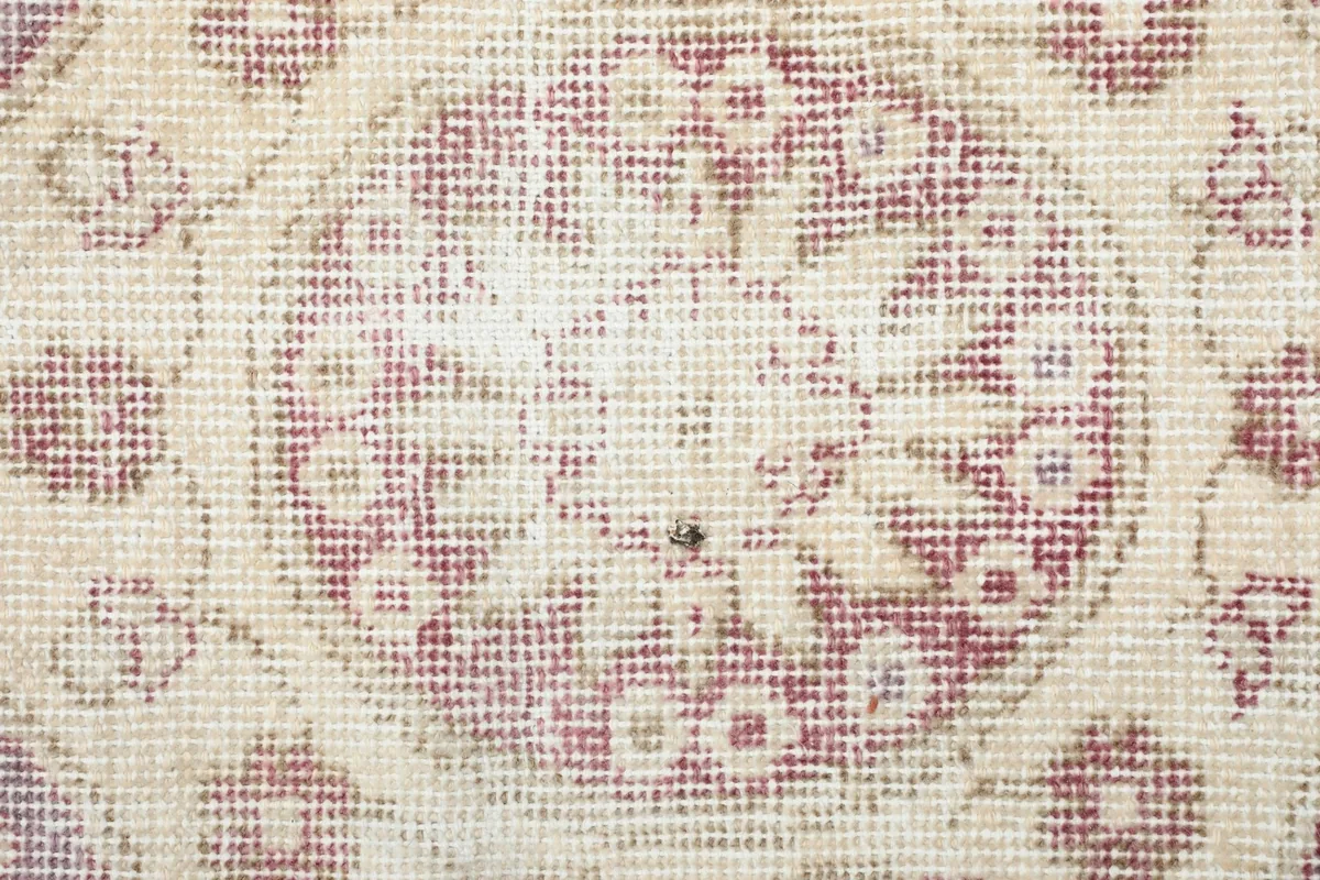 Extreme close-up of the low wool pile and hand-knotted texture of the rug
