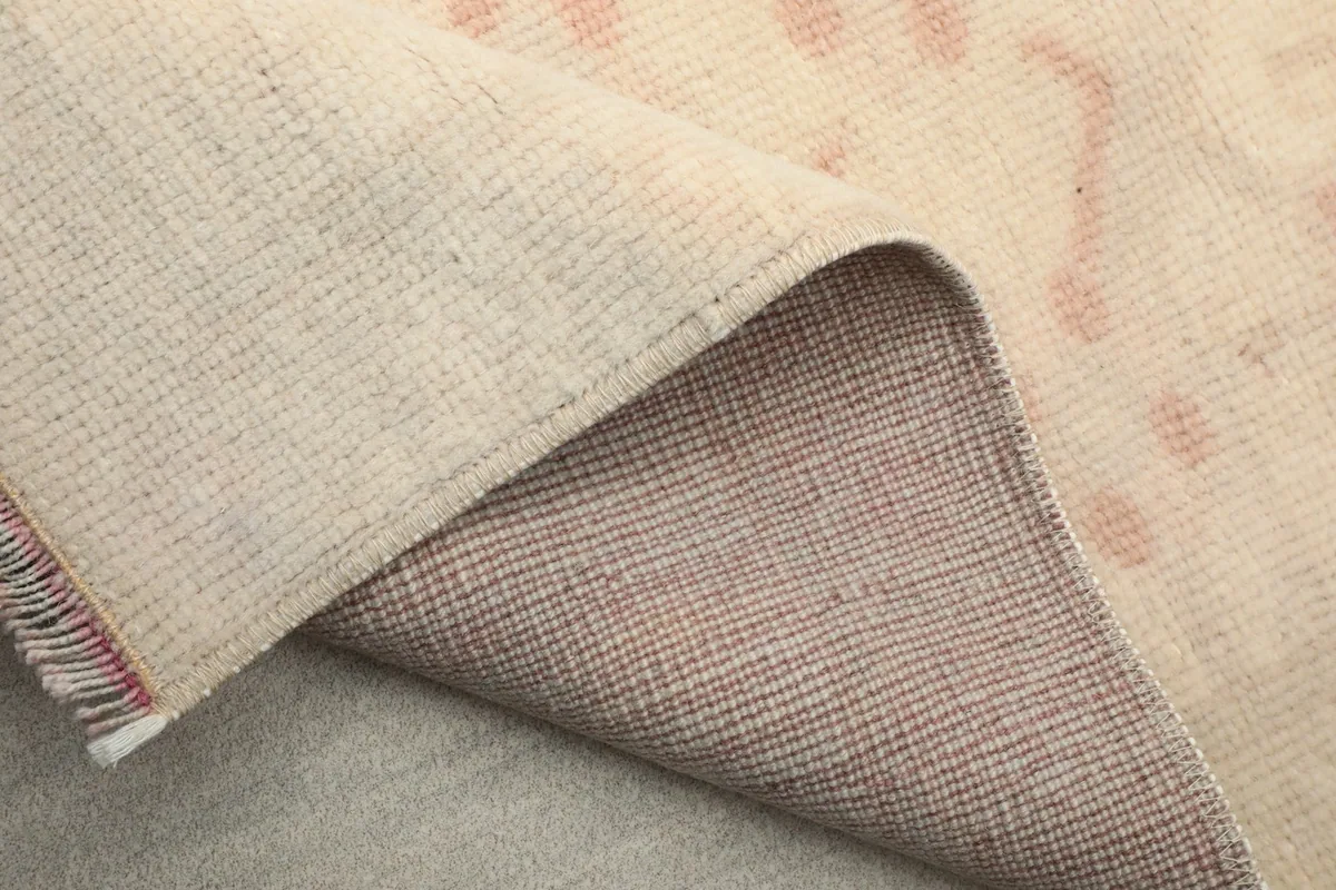Another view of the back of the rug, folded to show the weave and the cotton foundation.