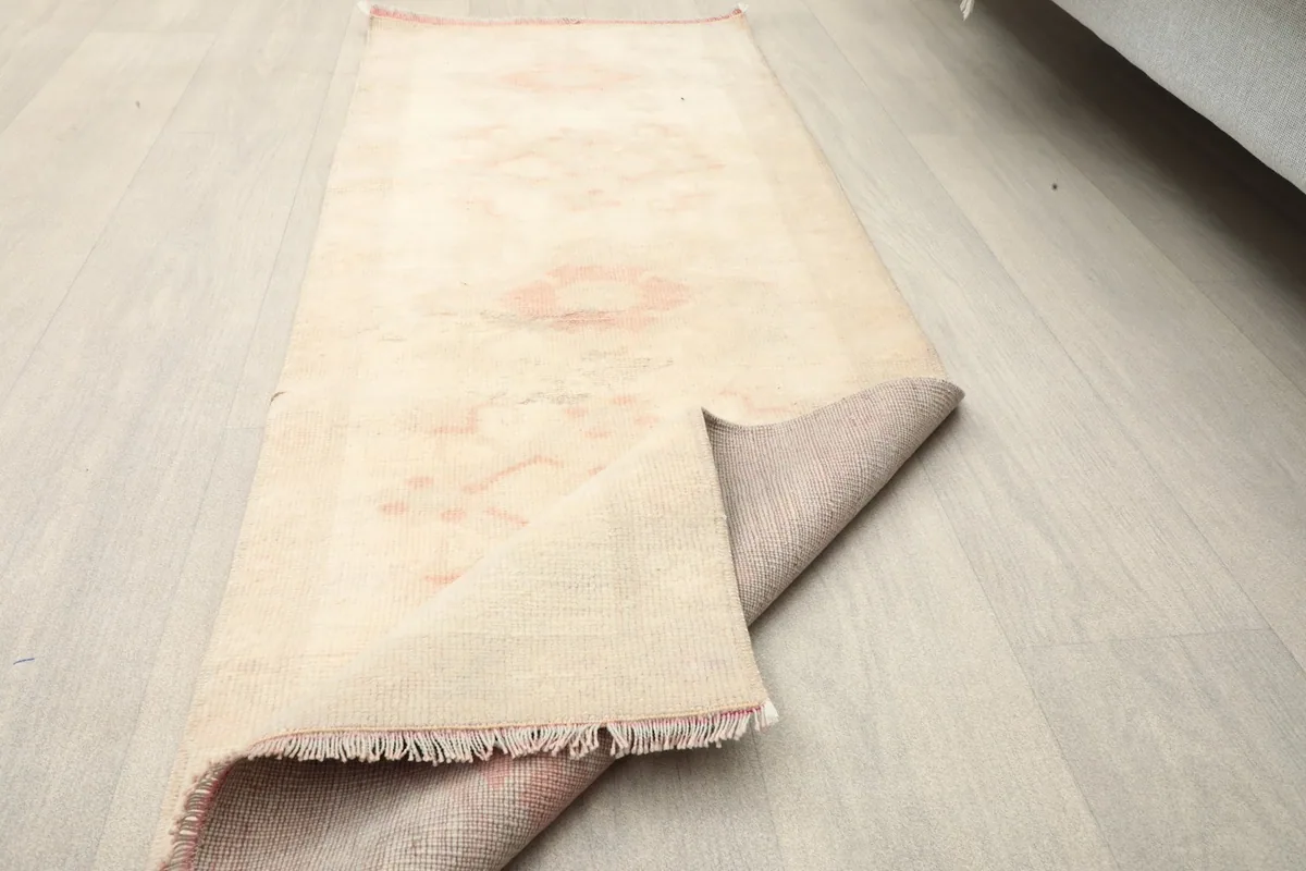 The runner rug partially folded on the floor, showing its flexibility and the underside.