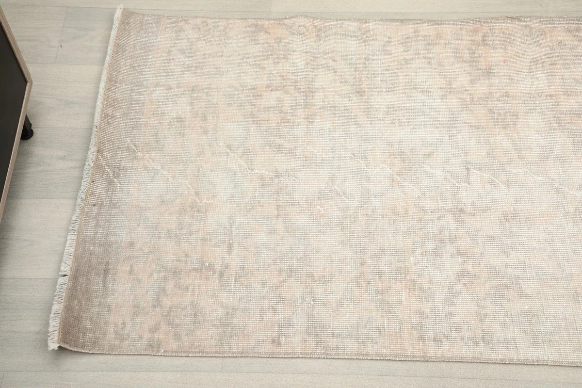 Detailed overhead shot of the rug's middle section, showing the gentle wear and vintage character of the wool pile.