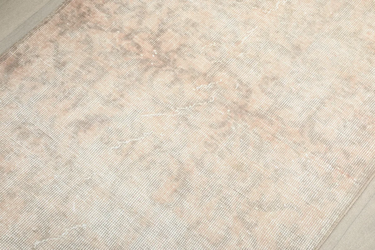 Close inspection of the low wool pile, highlighting the hand-knotted texture and soft, muted color transitions.