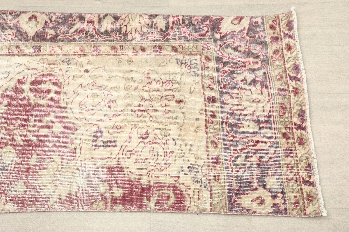 Detailed view of the runner's faded rose field and intricate ivory floral patterns, including the border design.