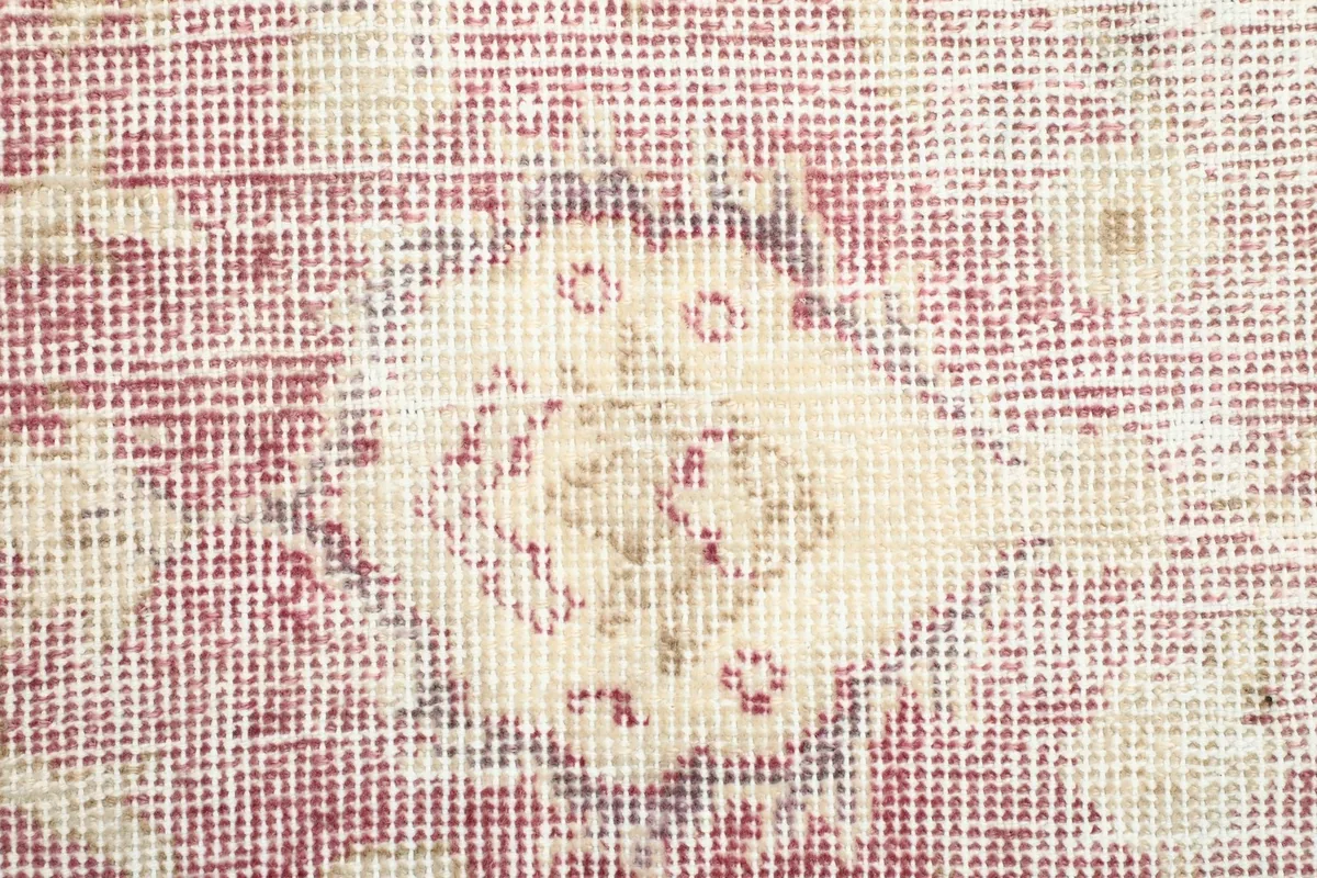An extreme close-up of a specific motif within the runner, illustrating the fine knotting and aged appearance.