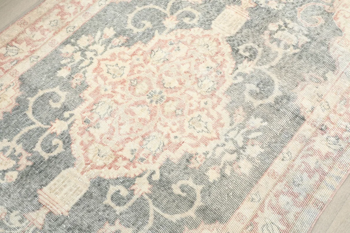 Detailed view of the central medallion, highlighting the rose and ivory floral elements