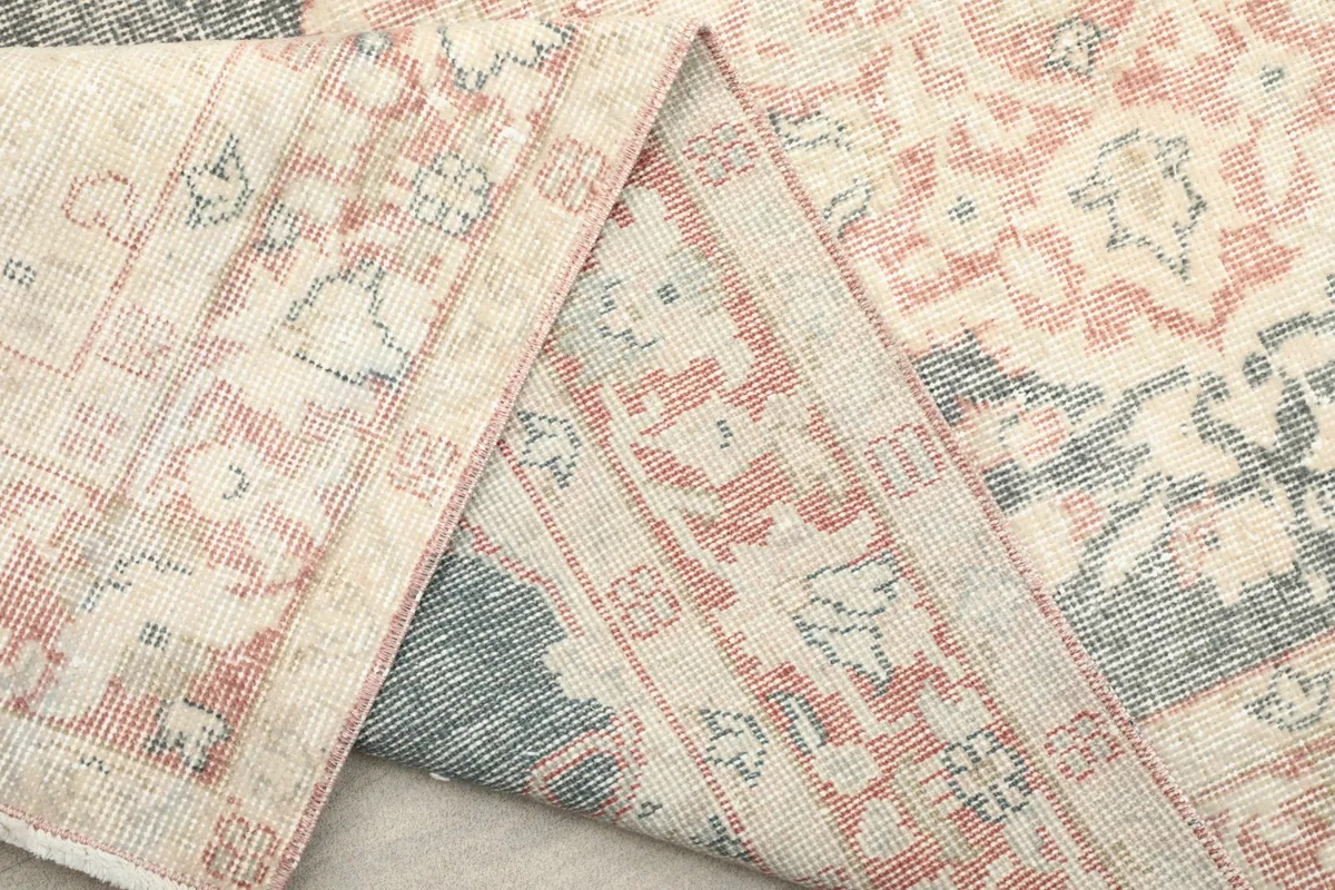 Mid-section of the rug folded, revealing the reverse side of the wool pile and cotton foundation