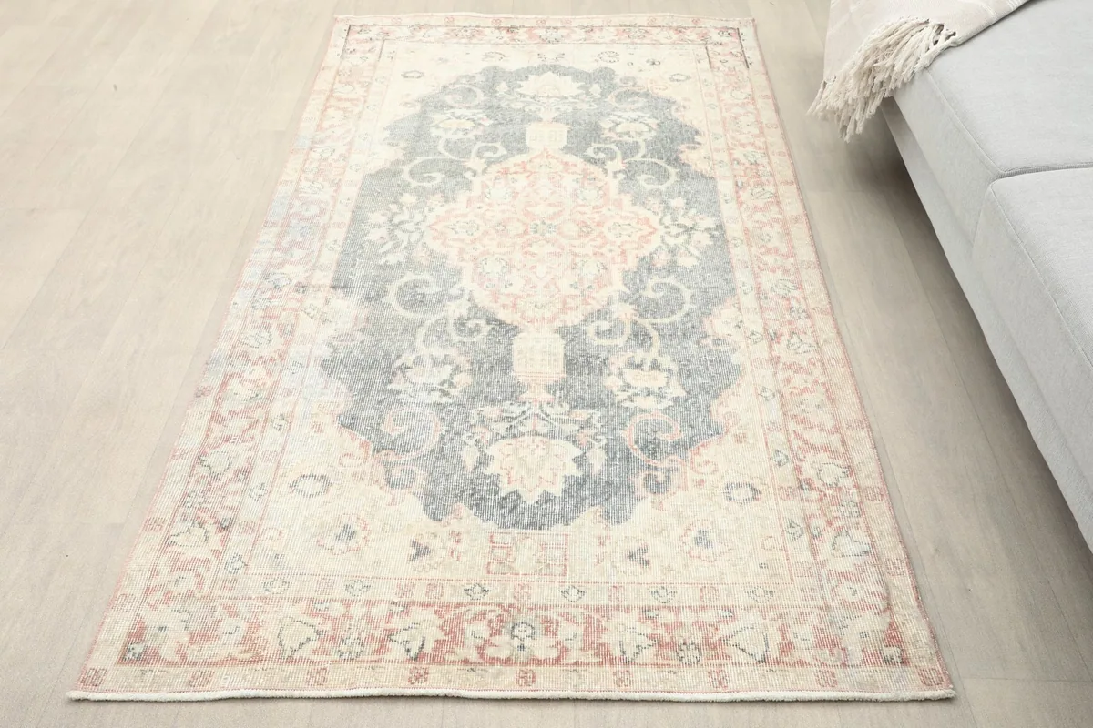 Overhead view of the vintage Anatolian rug in a room setting next to a gray sofa