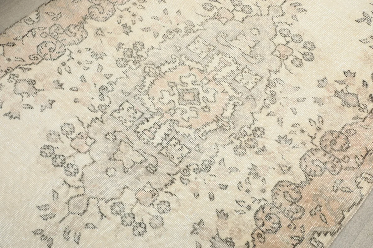 Detailed view of the central medallion and surrounding patterns, revealing the hand-knotted texture and color blend.